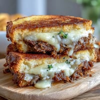 Gooey cheddar melts into tender short ribs in this stacked short rib grilled cheese.